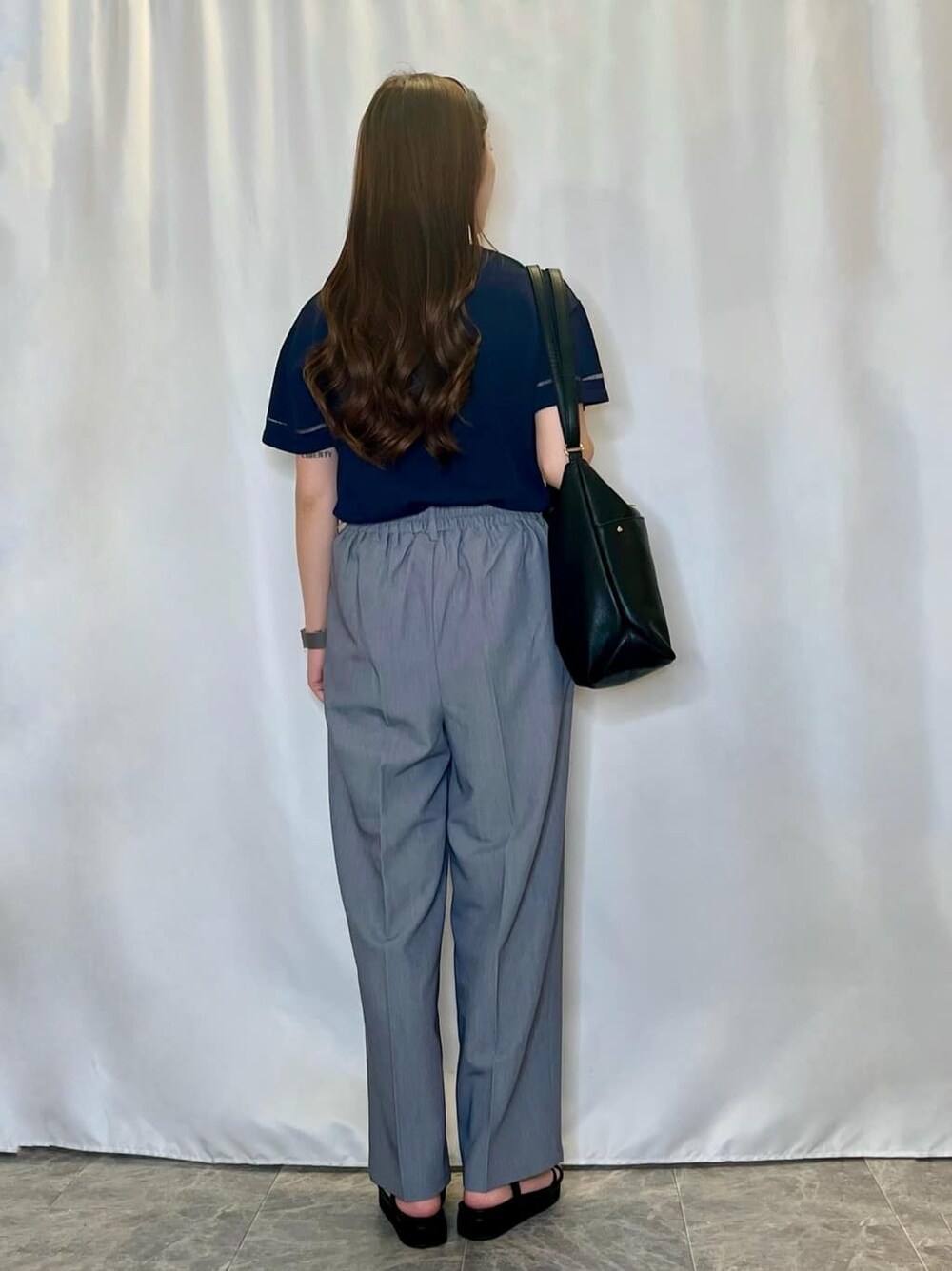 ブルー系のニット/セーター、グレー系のその他パンツ、ブラック系のサンダルを着用したレディースの夏コーディネートの3枚目の写真