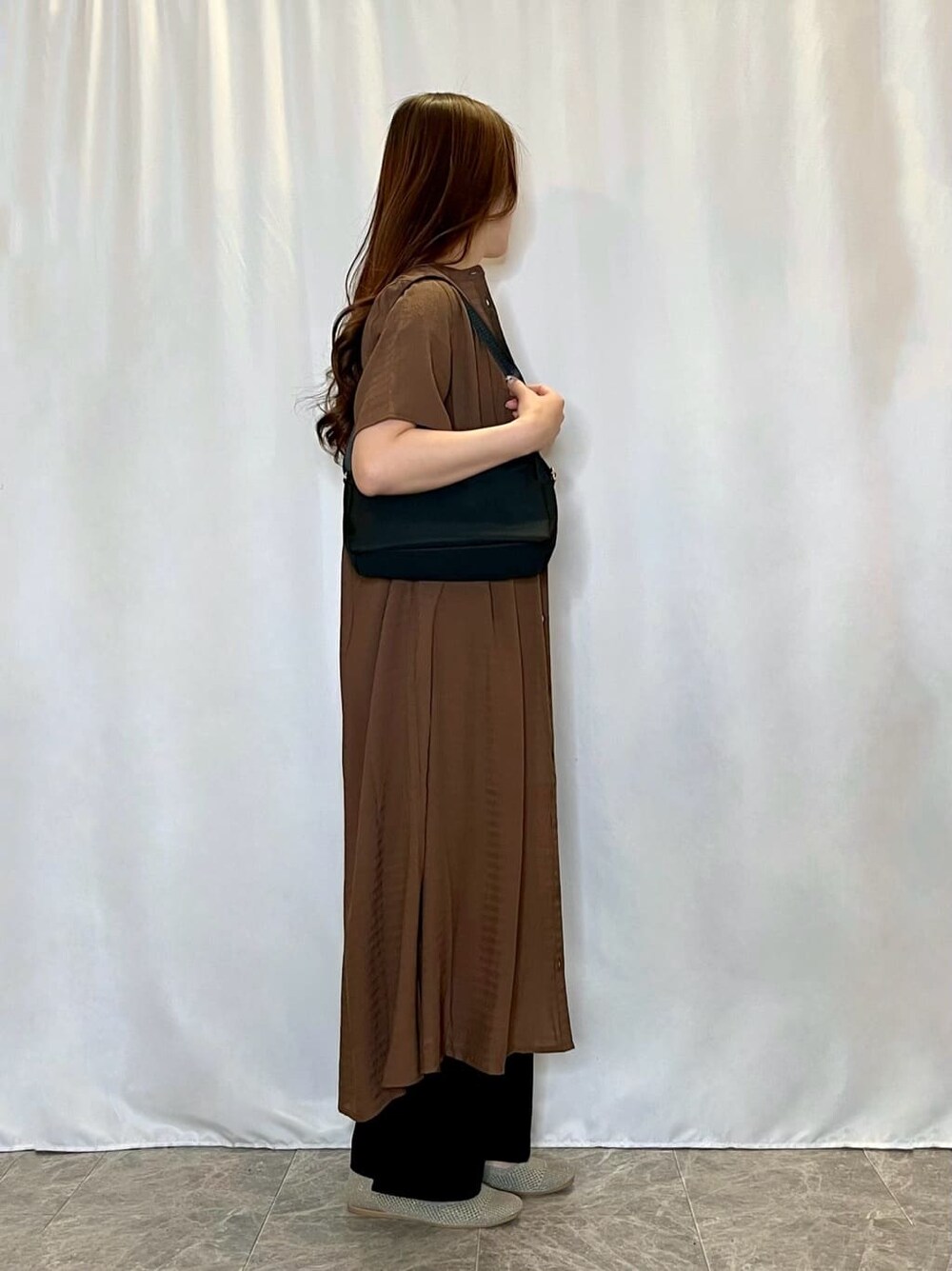 ブラウン系のワンピース、ゴールド系のタンクトップ、ブラック系のその他パンツを着用したレディースの春コーディネートの2枚目の写真
