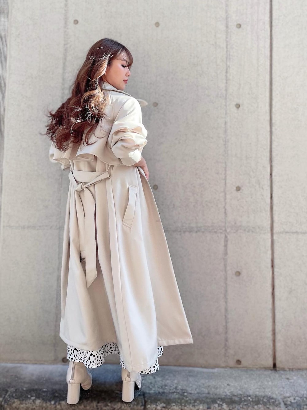 ホワイト系のトレンチコート、ホワイト系のワンピースを着用したレディースの春コーディネートの3枚目の写真