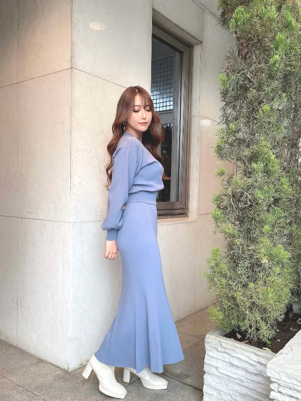 ブルー系のスカート、ブルー系のニット/セーター、ホワイト系のブーツを着用したレディースの冬コーディネートの3枚目の写真