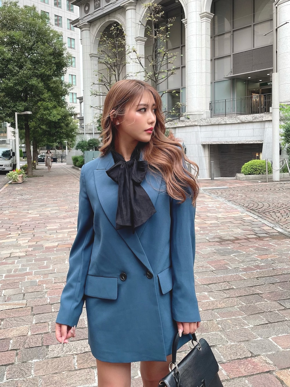 ブラック系のブーツ、ブラック系のバッグ、ブルー系のテーラードジャケットを着用したレディースの秋コーディネートの2枚目の写真