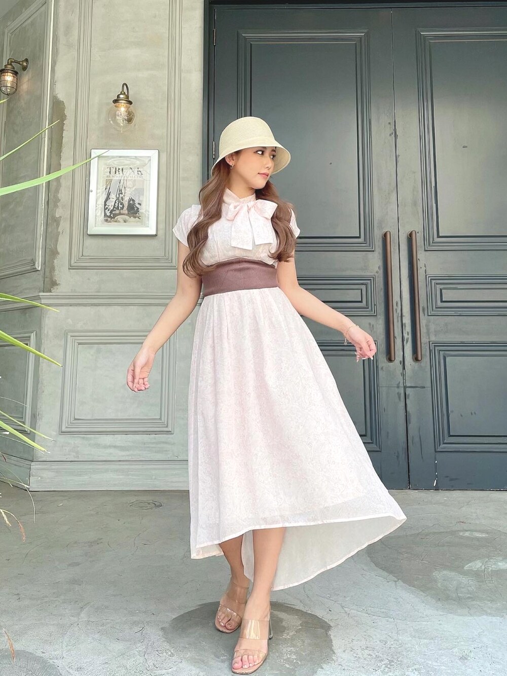 ピンク系のワンピース、その他のサンダル、ベージュ系のハットを着用したレディースの夏コーディネートの2枚目の写真