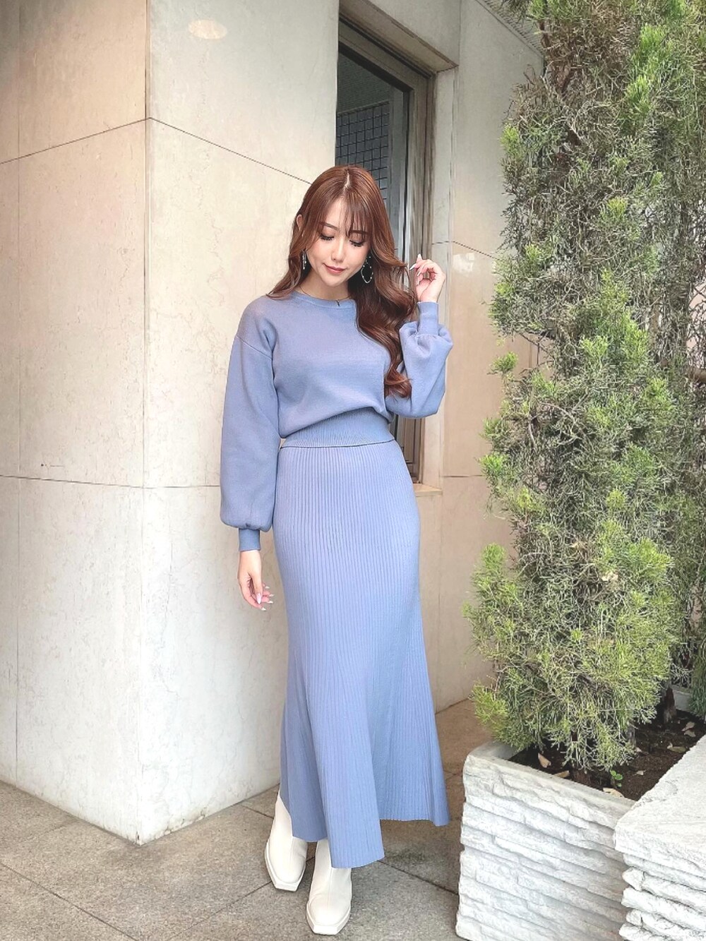 ブルー系のスカート、ブルー系のニット/セーター、ホワイト系のブーツを着用したレディースの冬コーディネートの2枚目の写真