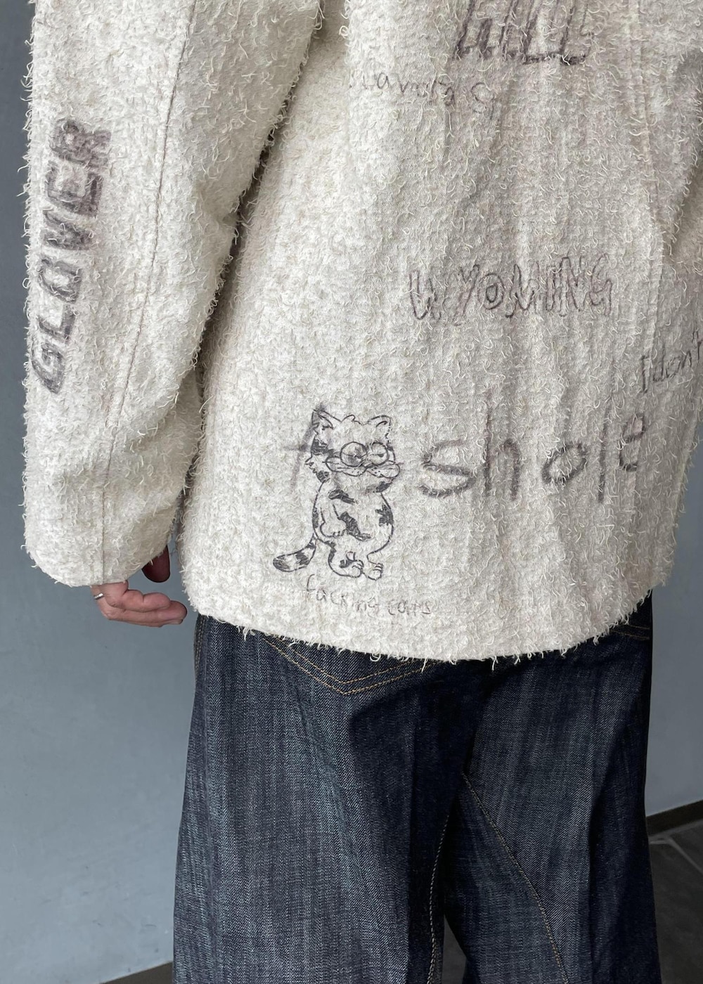 ブラック系のスリッポン、ブラック系のスウェット、ホワイト系のテーラードジャケットを着用したメンズの冬コーディネートの7枚目の写真