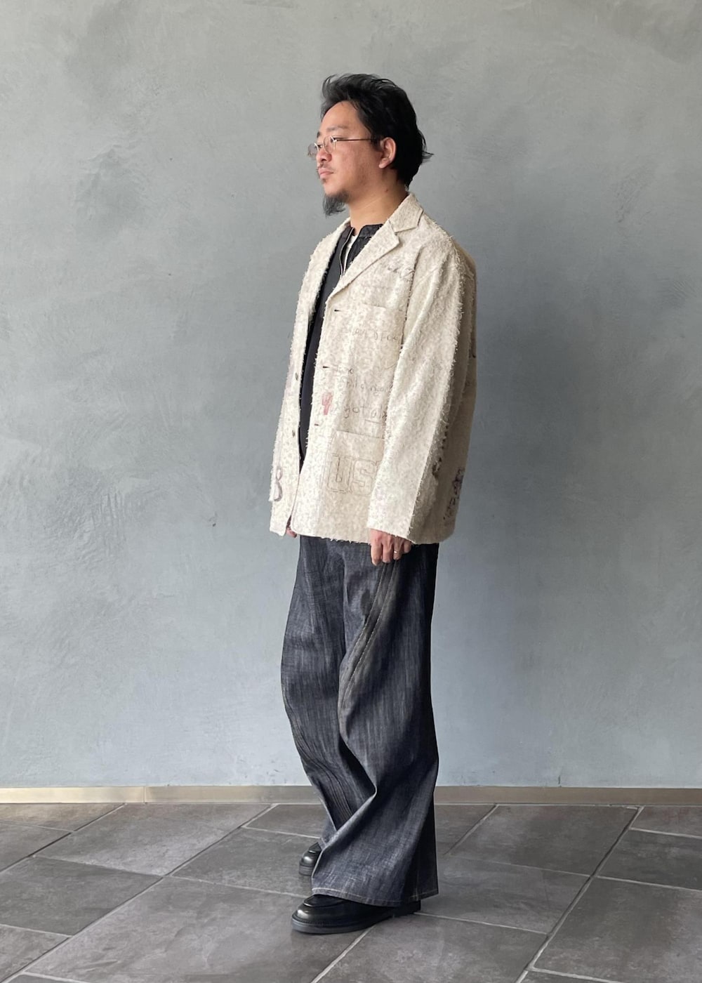 ブラック系のスリッポン、ブラック系のスウェット、ホワイト系のテーラードジャケットを着用したメンズの冬コーディネートの2枚目の写真