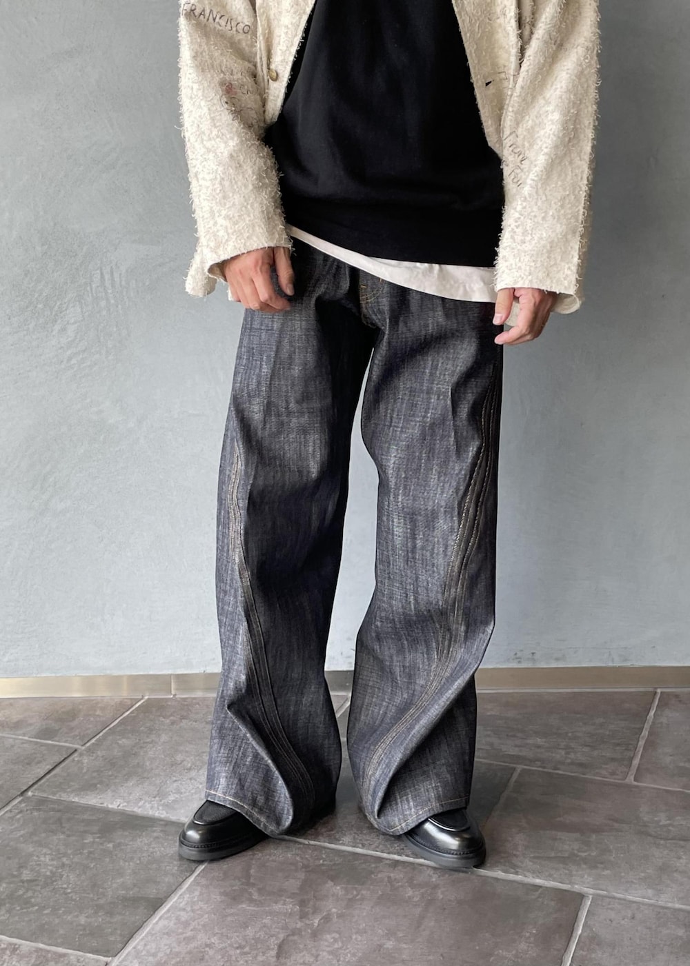 ブラック系のスリッポン、ブラック系のスウェット、ホワイト系のテーラードジャケットを着用したメンズの冬コーディネートの8枚目の写真