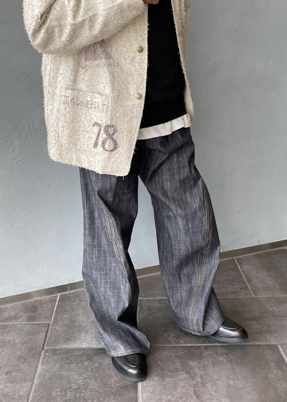 ブラック系のスリッポン、ブラック系のスウェット、ホワイト系のテーラードジャケットを着用したメンズの冬コーディネートの9枚目の写真