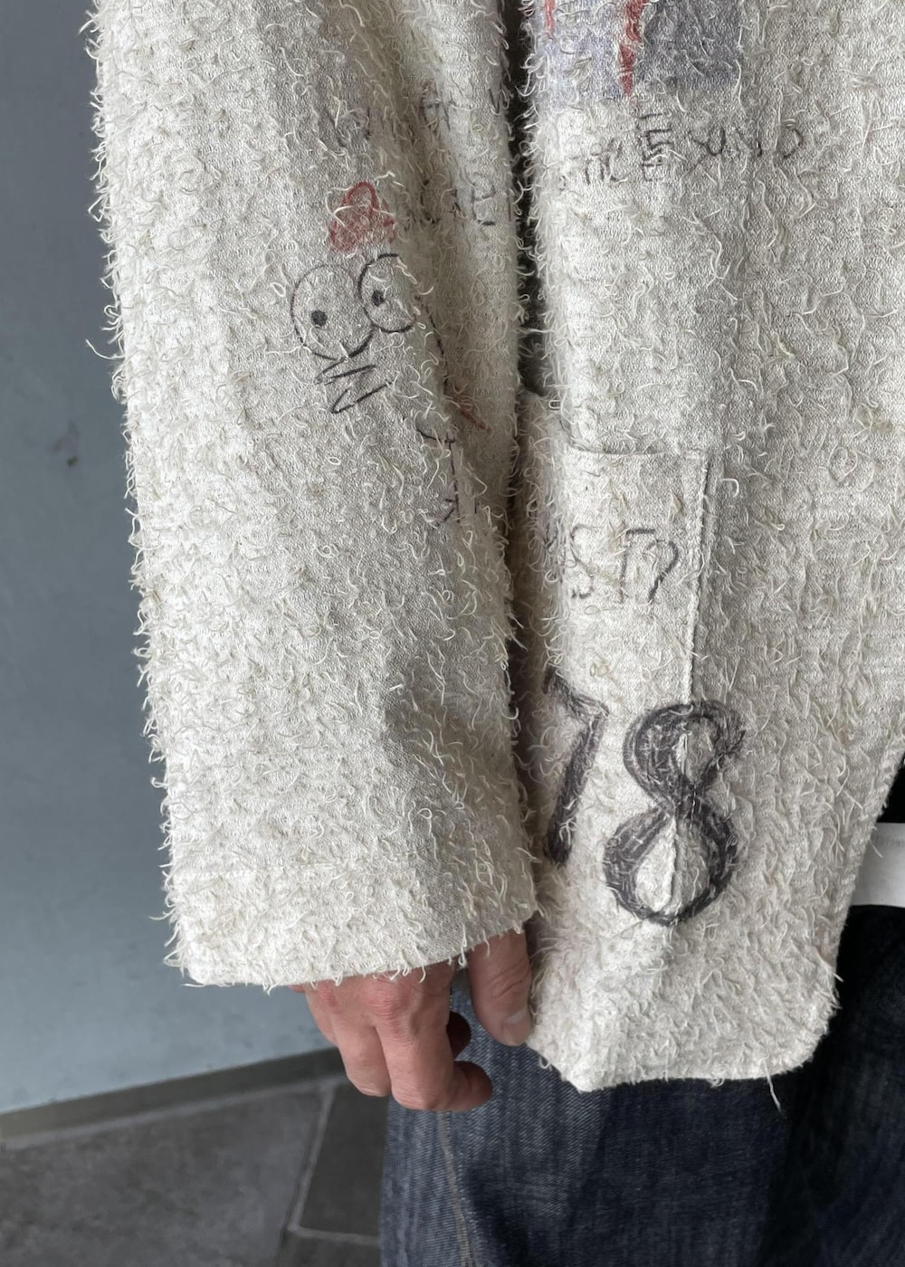 ブラック系のスリッポン、ブラック系のスウェット、ホワイト系のテーラードジャケットを着用したメンズの冬コーディネートの5枚目の写真