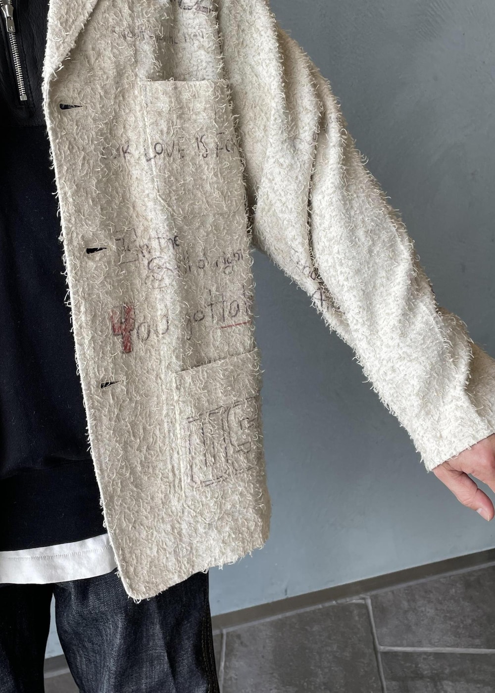 ブラック系のスリッポン、ブラック系のスウェット、ホワイト系のテーラードジャケットを着用したメンズの冬コーディネートの6枚目の写真