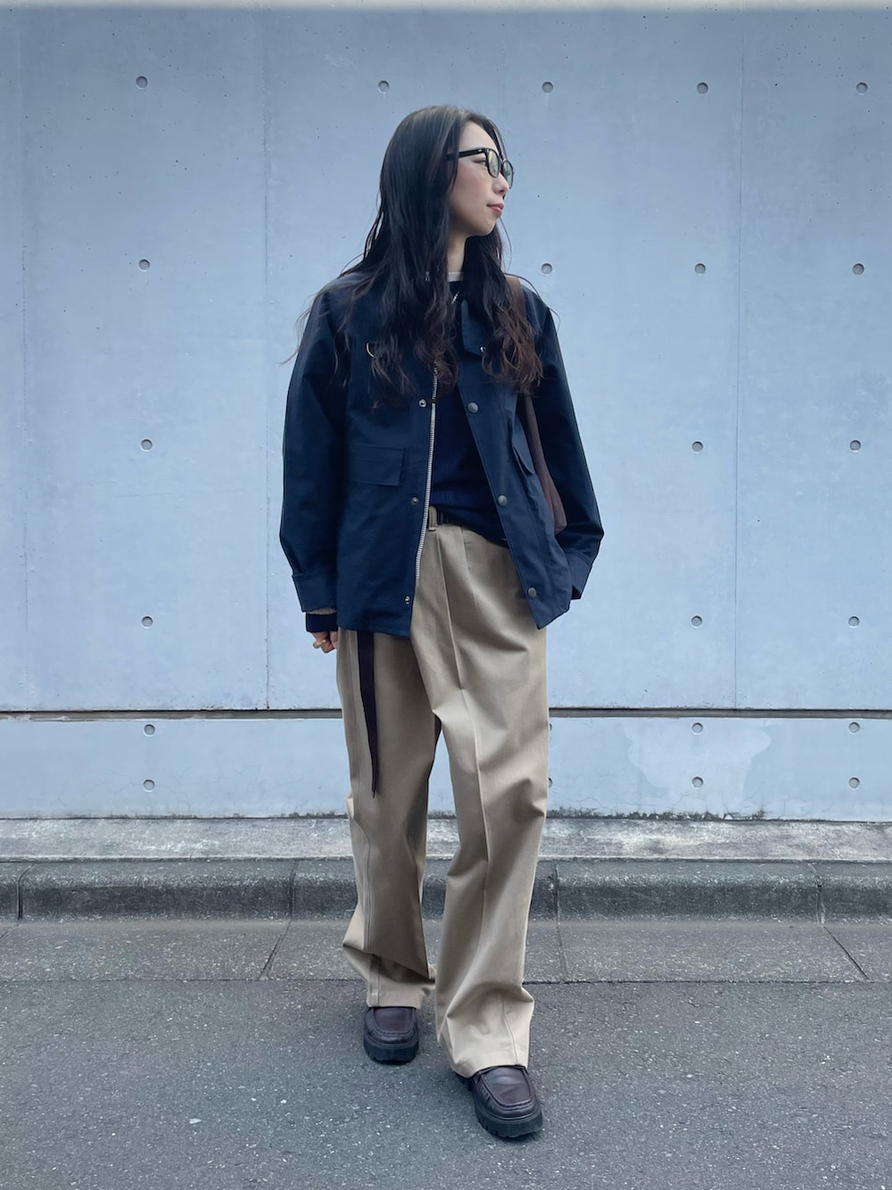 ブルー系のブルゾン、ブルー系のニット/セーター、ベージュ系のチノパンツを着用したレディースの春コーディネートの2枚目の写真