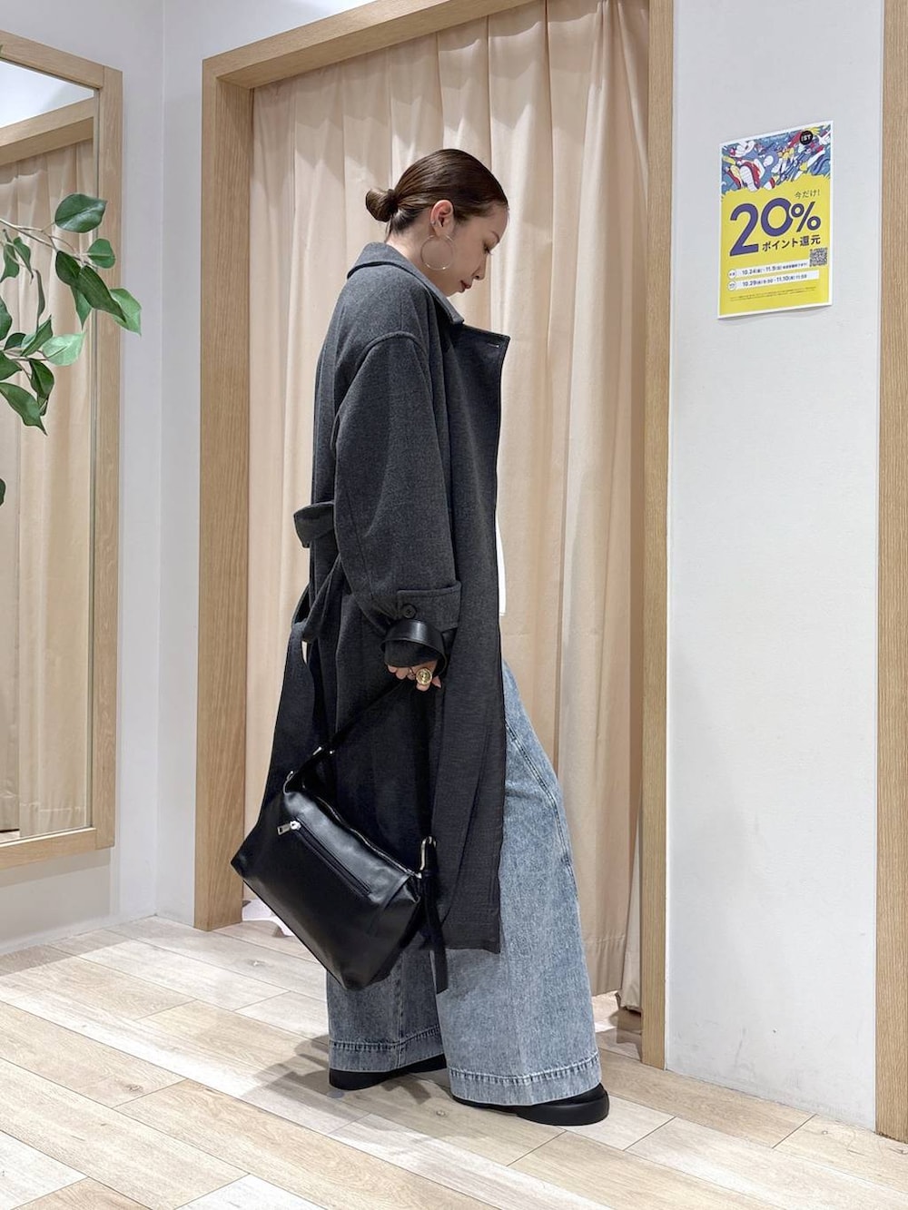 ブルー系のデニムパンツ、グレー系のステンカラーコート、ブラック系のショルダーバッグを着用したレディースの秋コーディネートの4枚目の写真