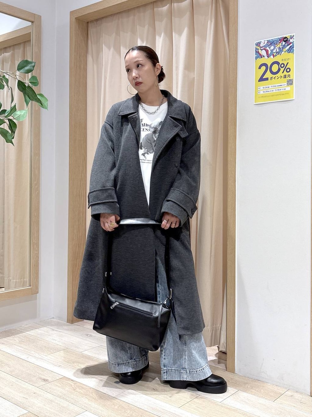 ブルー系のデニムパンツ、グレー系のステンカラーコート、ブラック系のショルダーバッグを着用したレディースの秋コーディネートの5枚目の写真