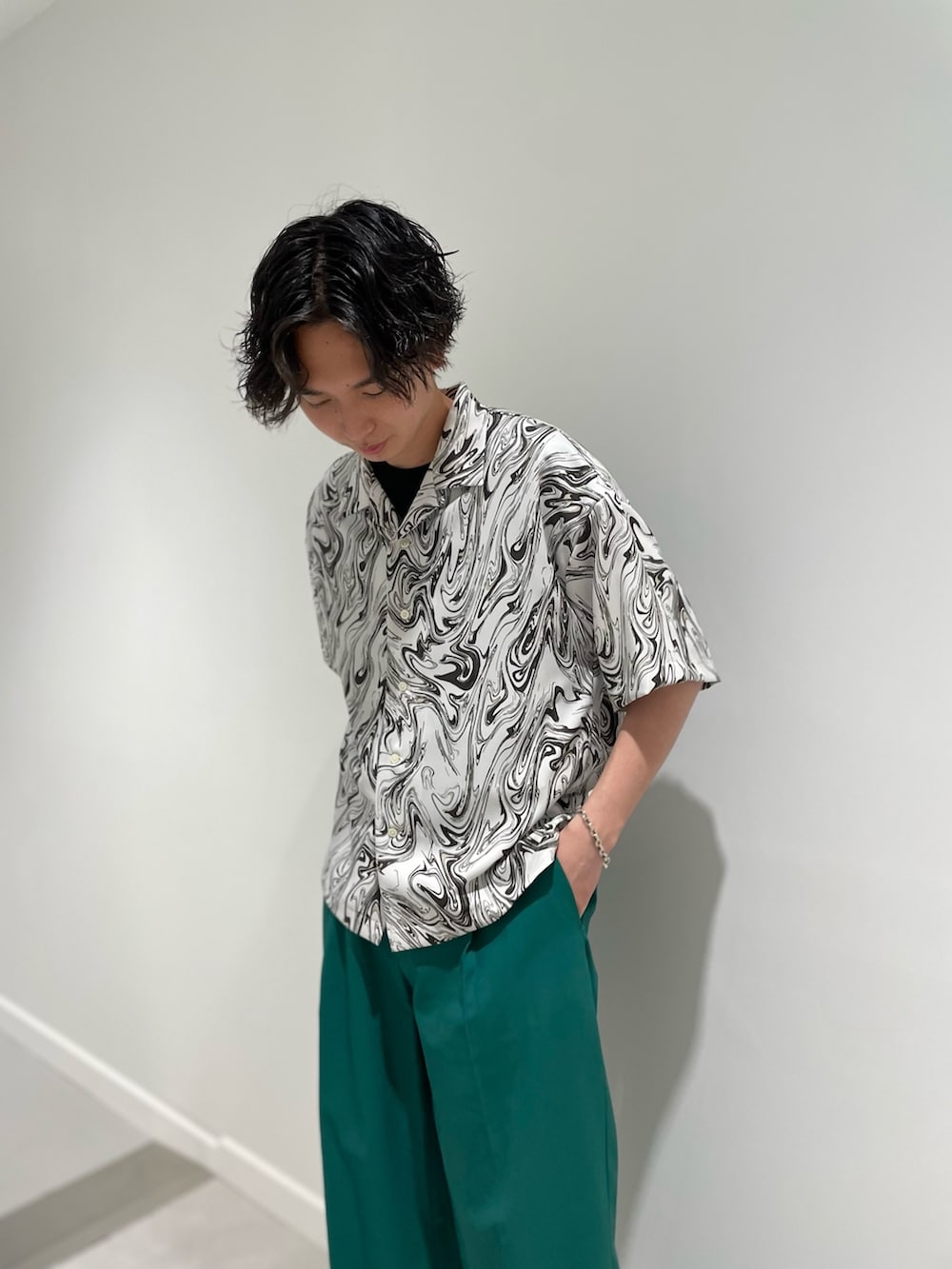 ブラック系のTシャツ/カットソー、ホワイト系のシャツ/ブラウス、グリーン系のパンツを着用したメンズの春コーディネートの2枚目の写真