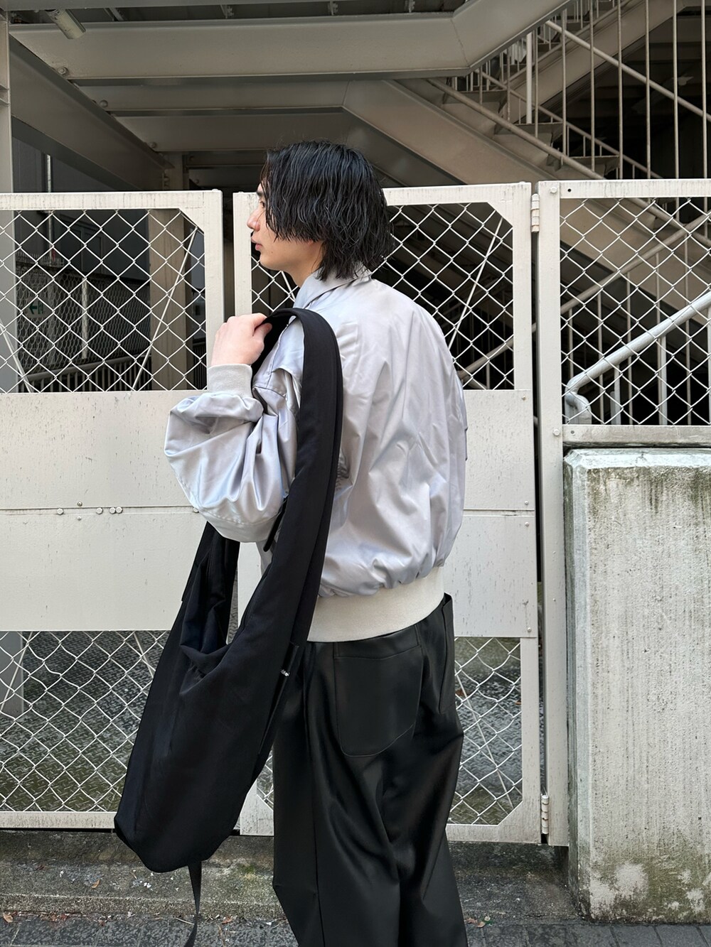 グレー系のブルゾン、ブラック系のパンツを着用したメンズの春コーディネートの2枚目の写真