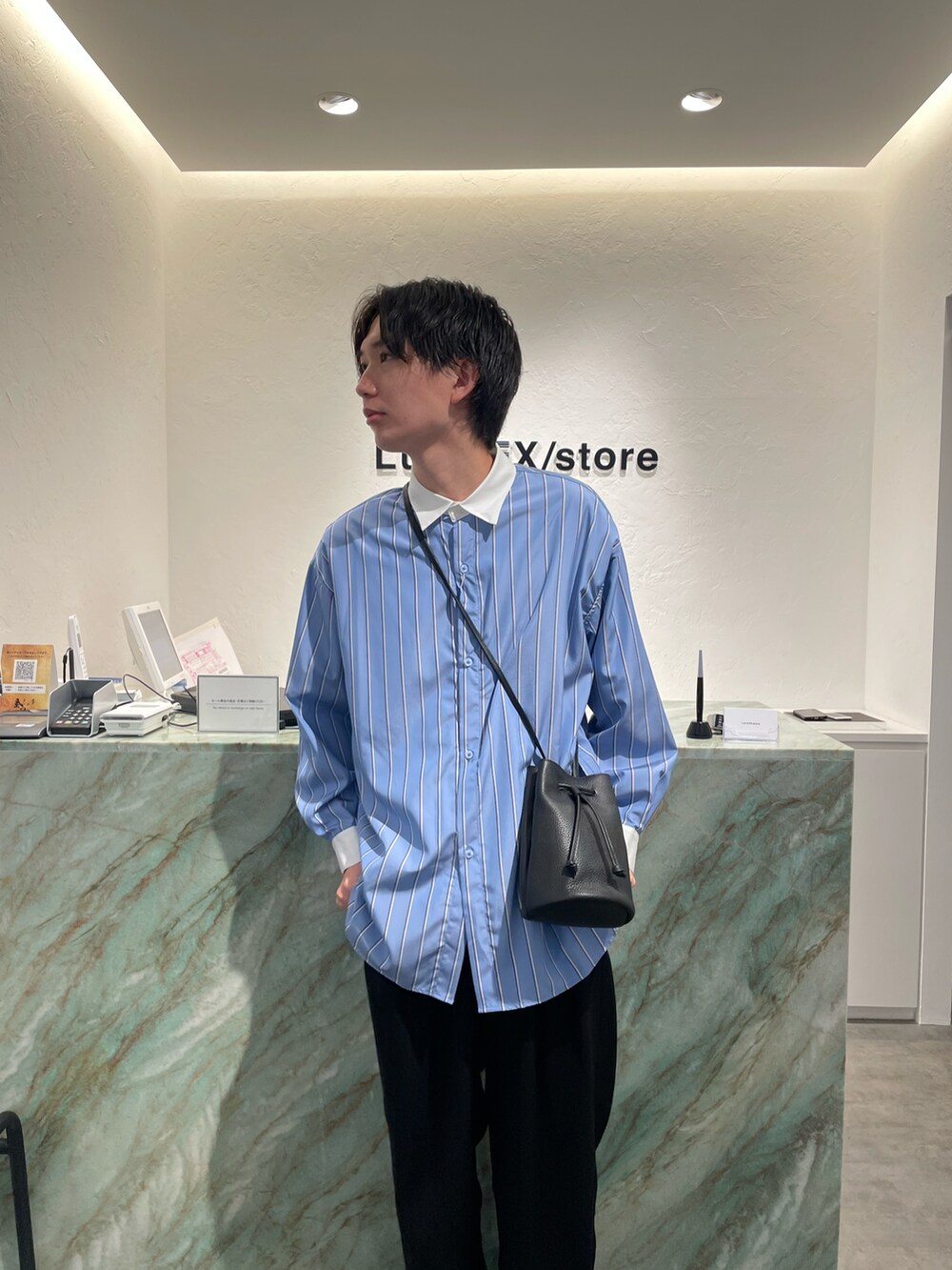 ブルー系のシャツ/ブラウス、ブラック系のショルダーバッグ、ブルー系のスラックスを着用したメンズの秋コーディネートの2枚目の写真