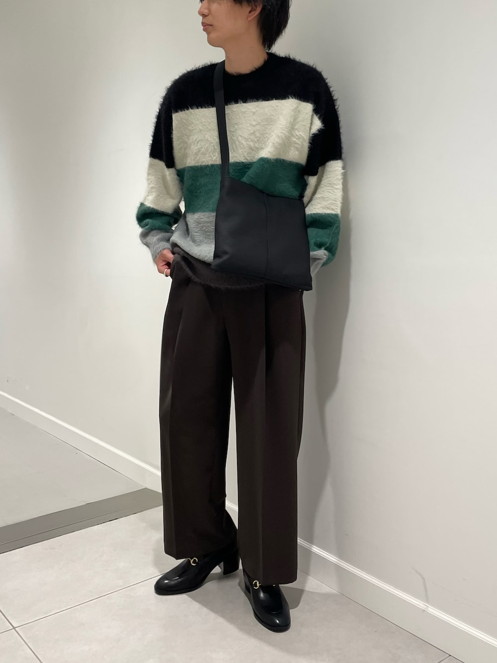 ブラック系のニット/セーター、ブラック系のトートバッグ、シルバー系のジャケット/アウターを着用したメンズの秋コーディネートの2枚目の写真