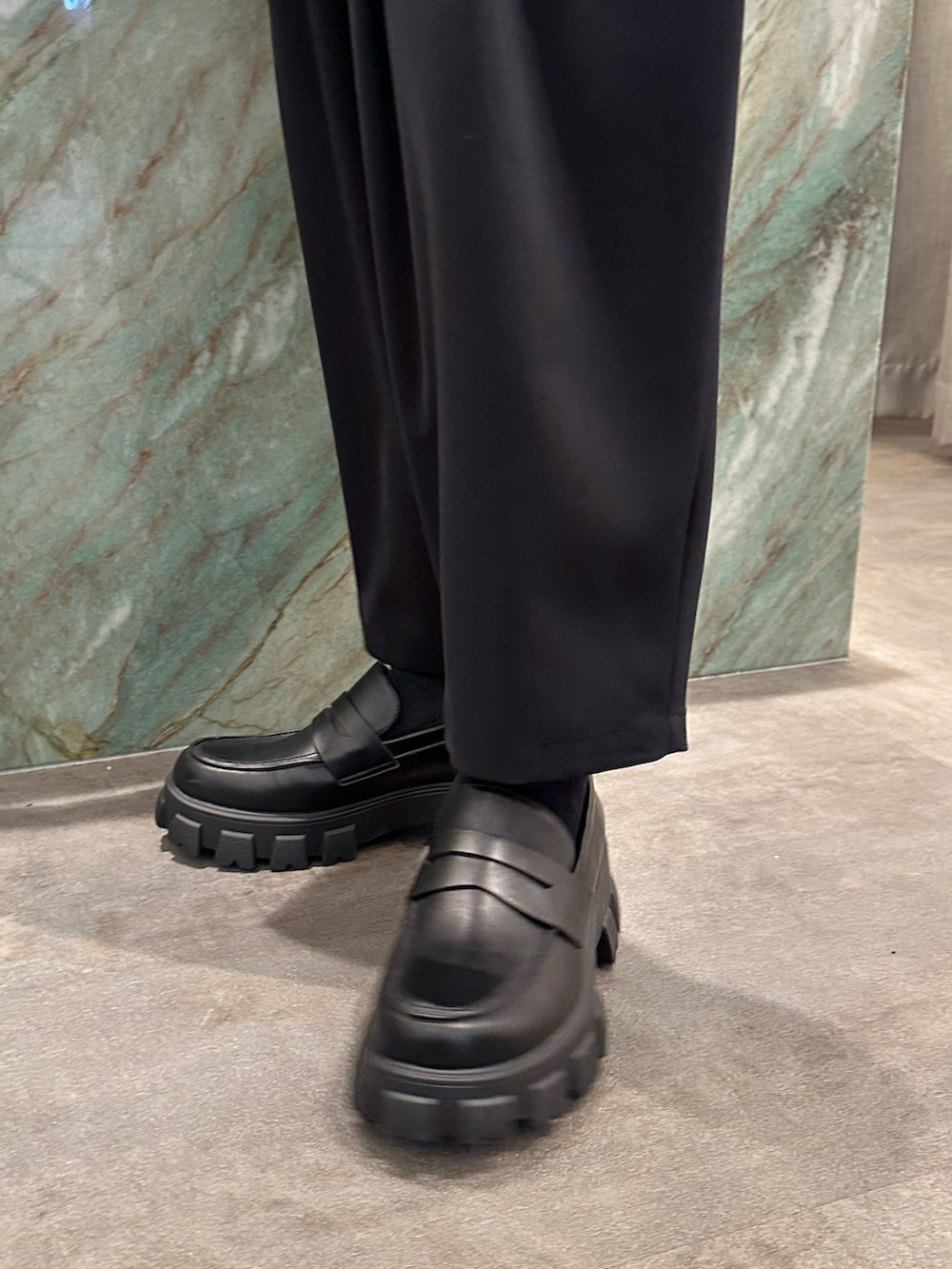 ブラック系のテーラードジャケット、グレー系のTシャツ/カットソー、ブラック系のその他パンツを着用したメンズの春コーディネートの5枚目の写真