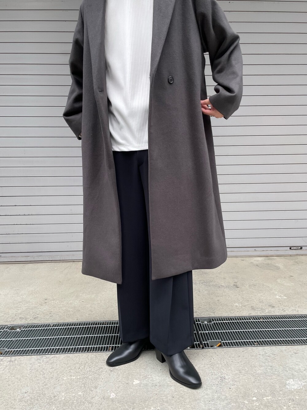 グレー系のチェスターコート、ホワイト系のTシャツ/カットソー、ブラック系のその他パンツを着用したメンズの冬コーディネートの4枚目の写真