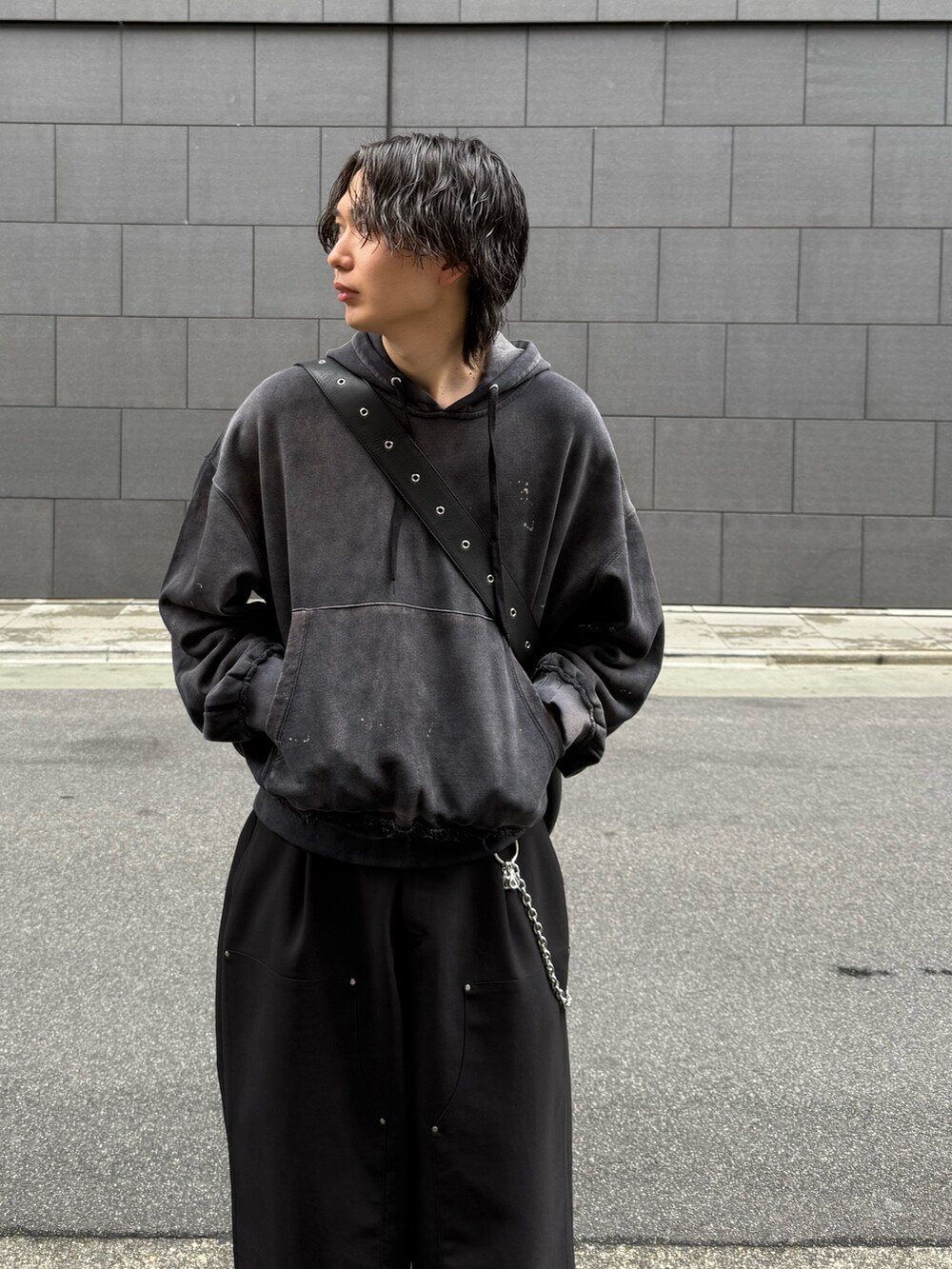 ブラック系のその他パンツ、ブラック系のトートバッグ、ブラック系のパーカーを着用したメンズの春コーディネートの2枚目の写真