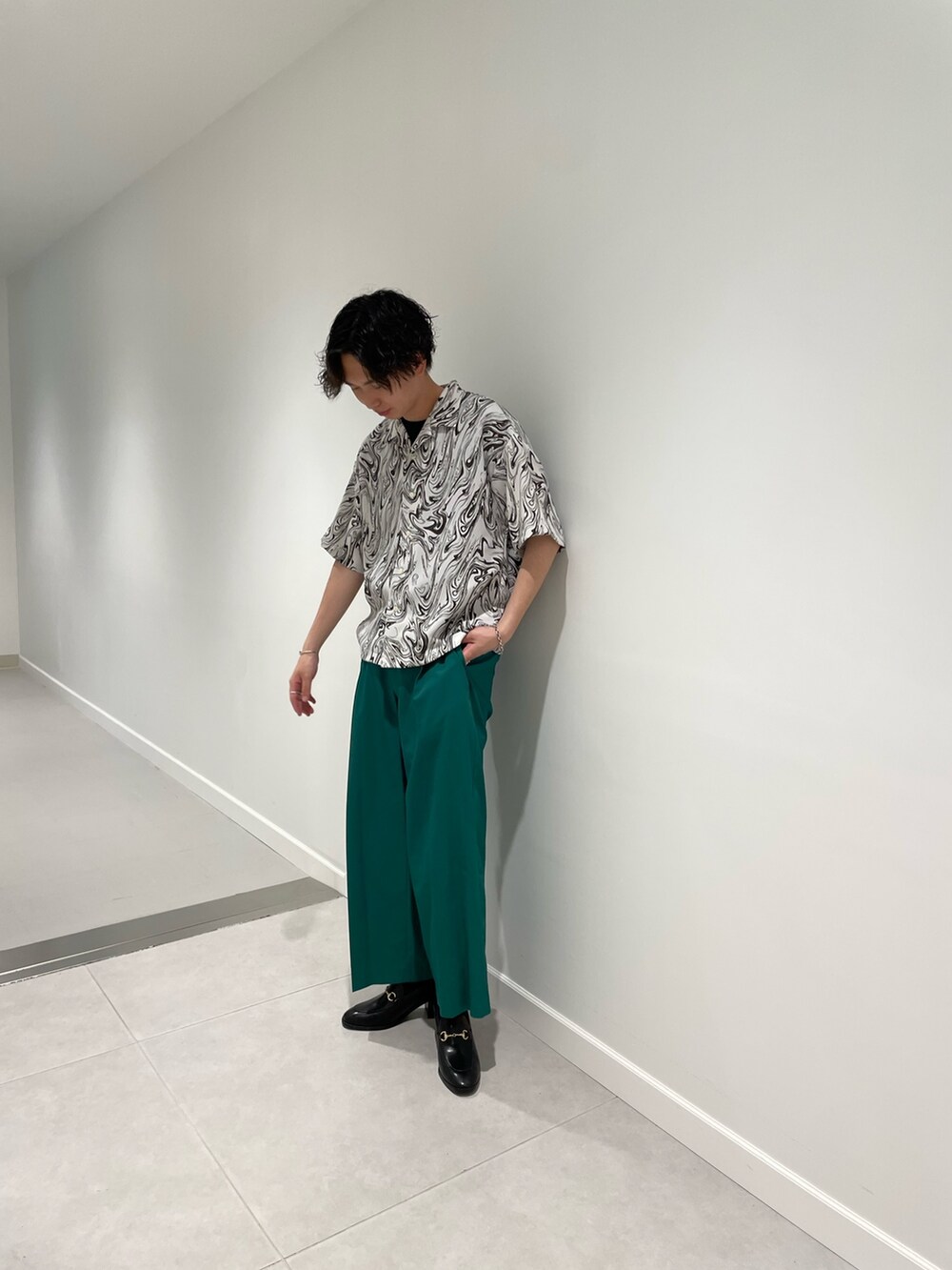 ブラック系のTシャツ/カットソー、ホワイト系のシャツ/ブラウス、グリーン系のパンツを着用したメンズの春コーディネートの5枚目の写真