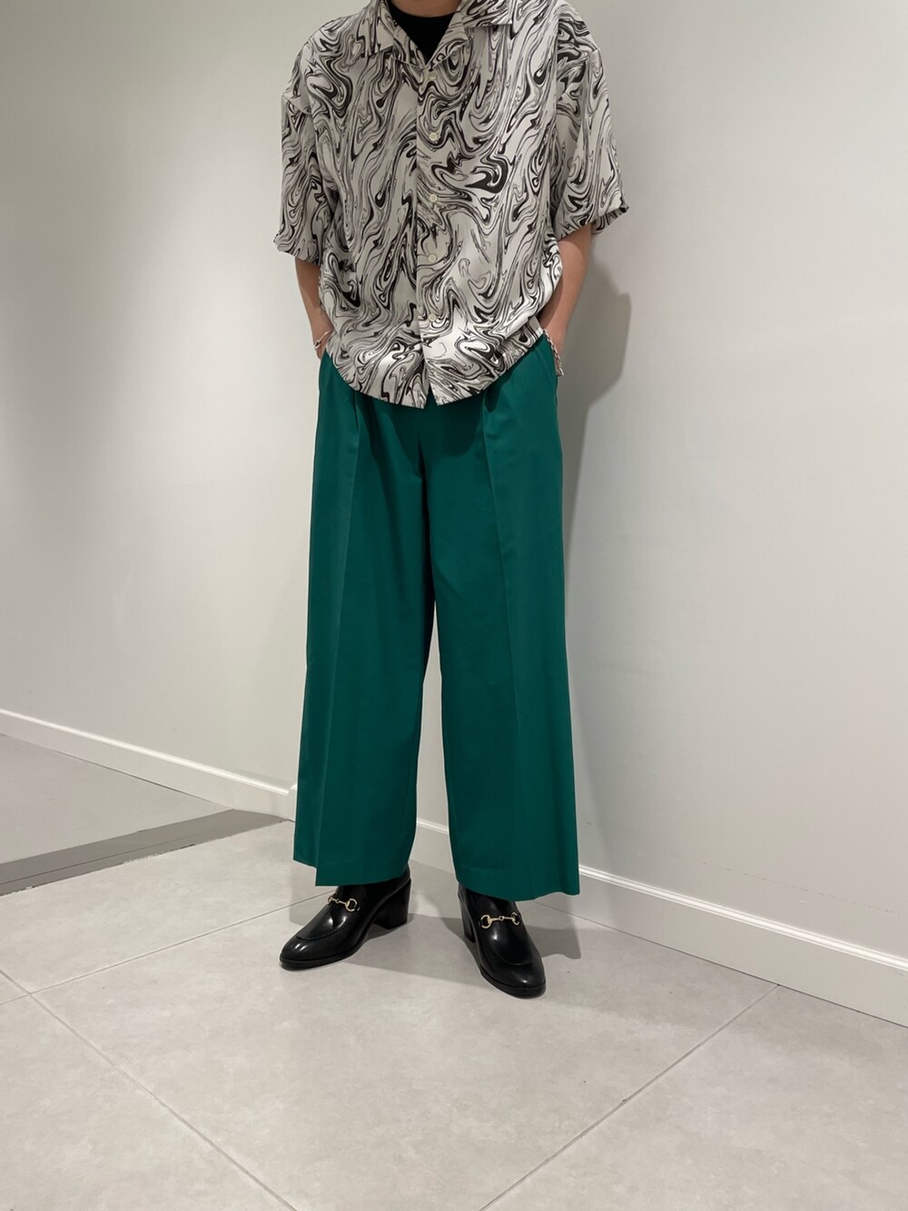 ブラック系のTシャツ/カットソー、ホワイト系のシャツ/ブラウス、グリーン系のパンツを着用したメンズの春コーディネートの3枚目の写真