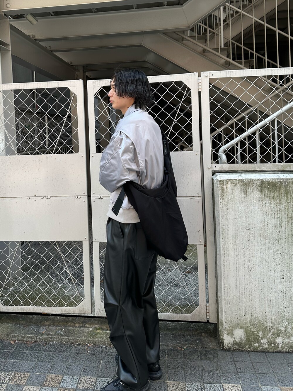 グレー系のブルゾン、ブラック系のパンツを着用したメンズの春コーディネートの5枚目の写真