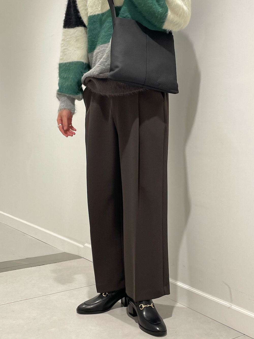 ブラック系のニット/セーター、ブラック系のトートバッグ、シルバー系のジャケット/アウターを着用したメンズの秋コーディネートの4枚目の写真