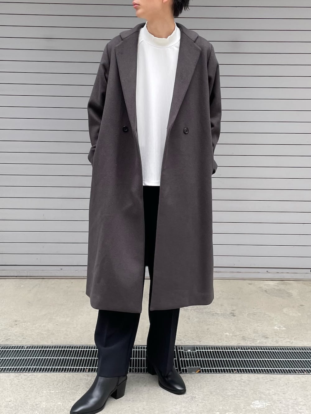 グレー系のチェスターコート、ホワイト系のTシャツ/カットソー、ブラック系のその他パンツを着用したメンズの冬コーディネートの5枚目の写真