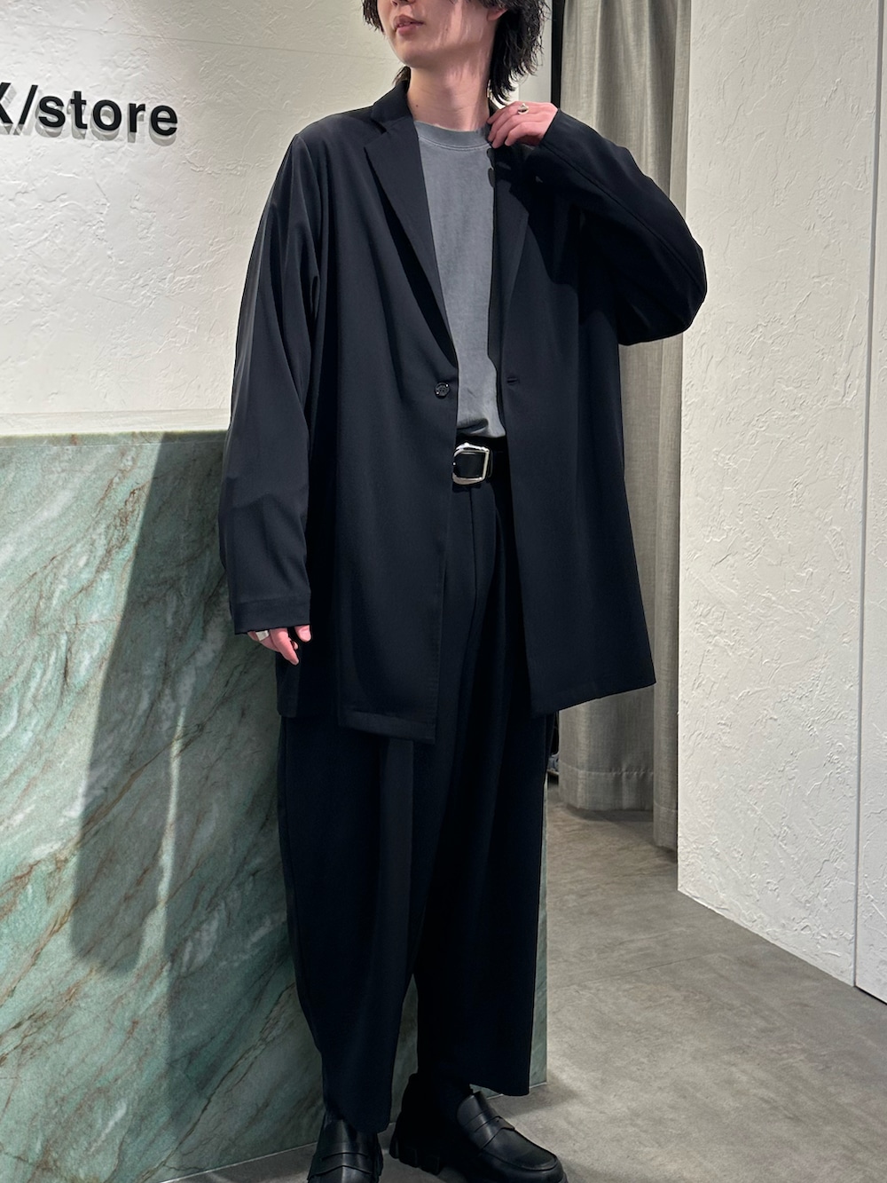 ブラック系のテーラードジャケット、グレー系のTシャツ/カットソー、ブラック系のその他パンツを着用したメンズの春コーディネートの2枚目の写真