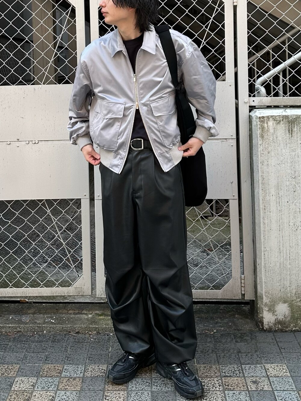 グレー系のブルゾン、ブラック系のパンツを着用したメンズの春コーディネートの3枚目の写真