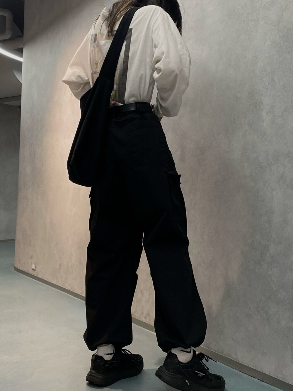 ブラック系のスニーカー、ブラック系のカーゴパンツ、ホワイト系のTシャツ/カットソーを着用したレディースの春コーディネートの2枚目の写真