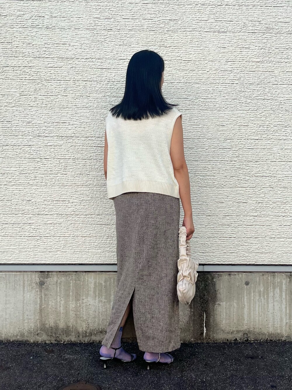 ホワイト系のニット/セーター、ベージュ系のスカート、ホワイト系のハンドバッグを着用したレディースの秋コーディネートの3枚目の写真