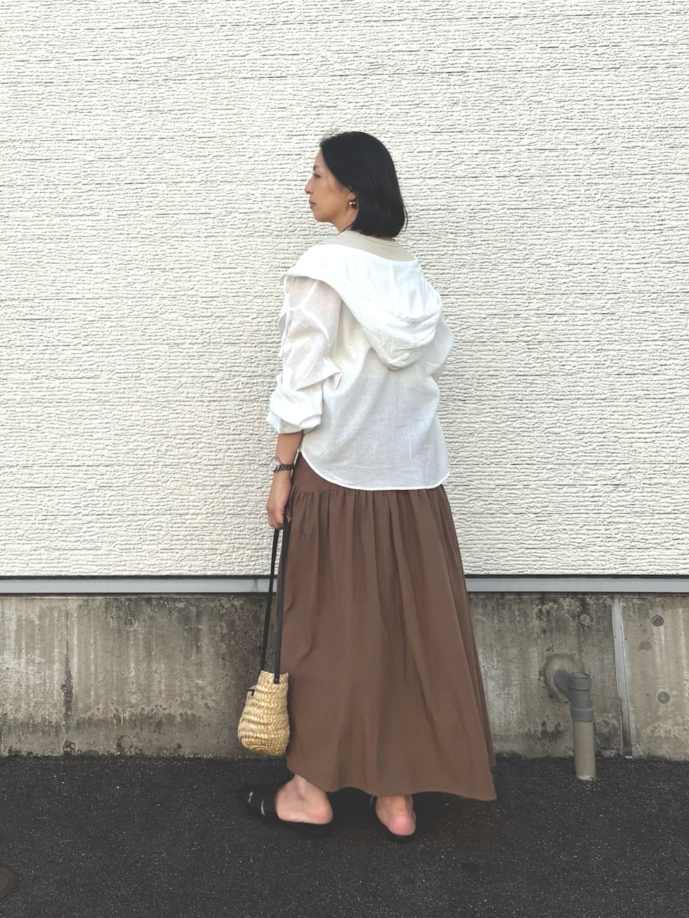 ベージュ系のワンピース、ホワイト系のシャツ/ブラウス、ブラック系のサンダルを着用したレディースの夏コーディネートの3枚目の写真
