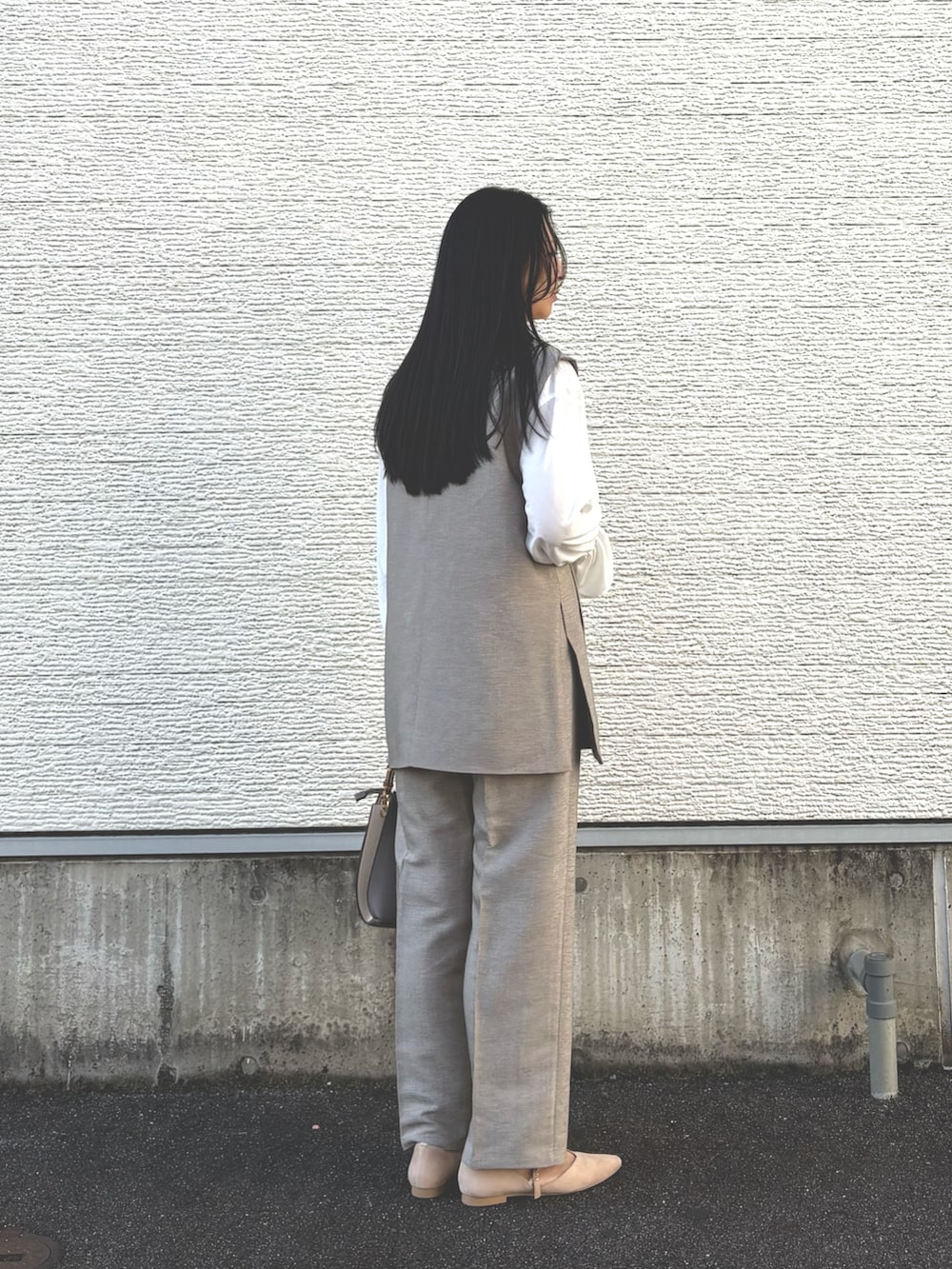 その他のハンドバッグ、ホワイト系のパンプス、ベージュ系のセットアップを着用したレディースの冬コーディネートの3枚目の写真