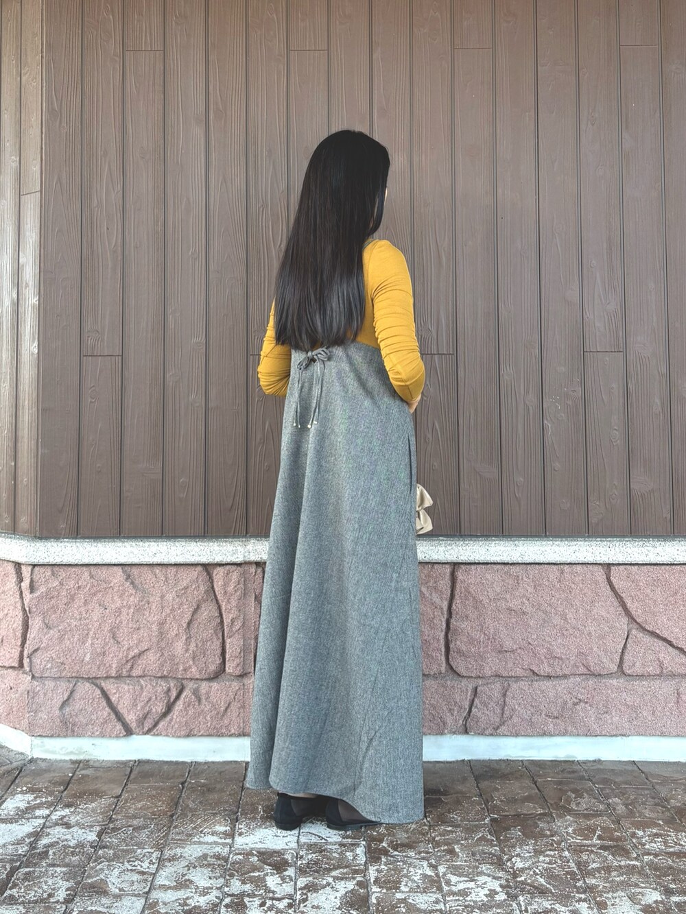 ブラック系のワンピース、イエロー系のTシャツ/カットソー、ベージュ系のハンドバッグを着用したレディースの秋コーディネートの4枚目の写真