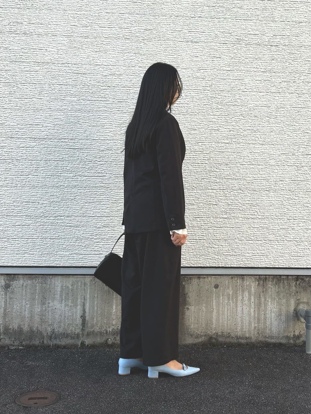 ブラック系のその他アウター、ブルー系のパンプス、ブラック系のその他パンツを着用したレディースの冬コーディネートの3枚目の写真