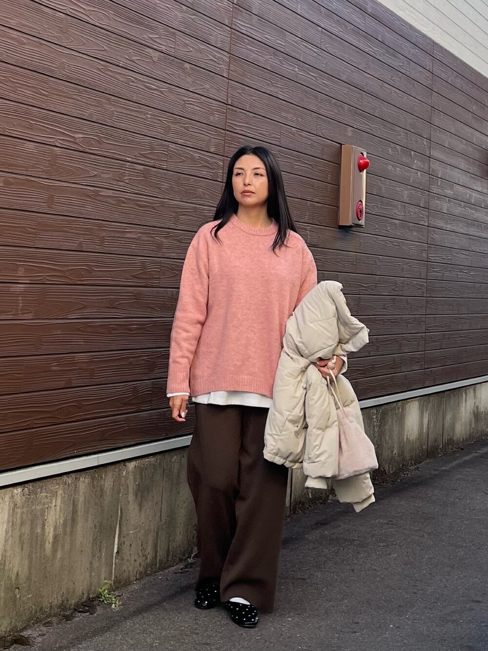 ピンク系のニット/セーター、グレー系のダウンジャケット/コート、ホワイト系のTシャツ/カットソーを着用したレディースの冬コーディネートの3枚目の写真