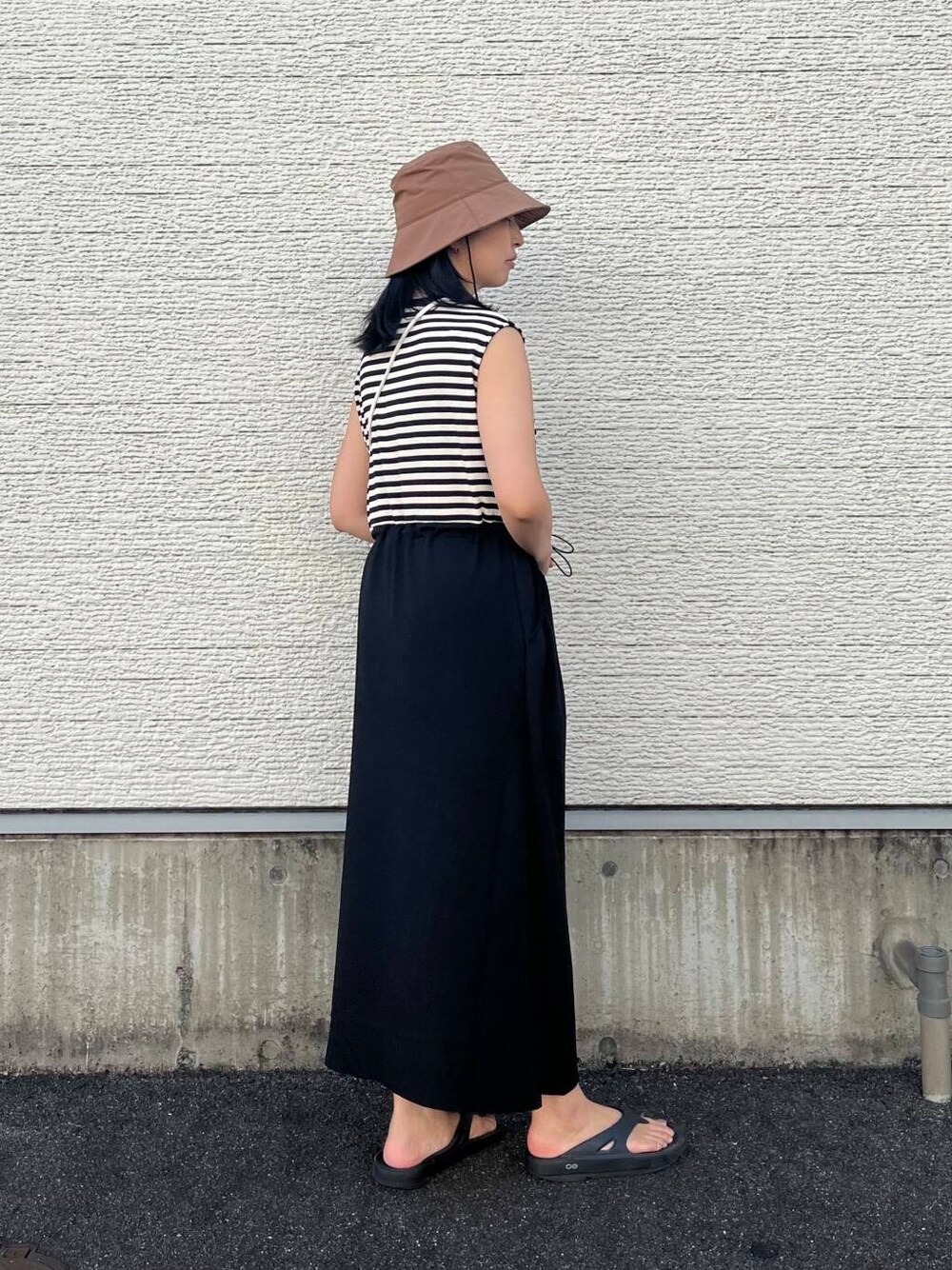 ブラック系のワンピース、ホワイト系のショルダーバッグ、ブラウン系のハットを着用したレディースの夏コーディネートの3枚目の写真