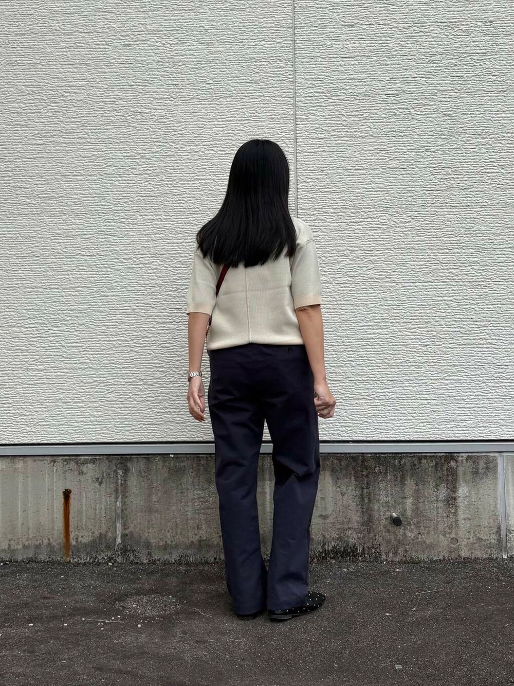 レッド系のショルダーバッグ、ブルー系のその他パンツ、ホワイト系のニット/セーターを着用したレディースの春コーディネートの2枚目の写真