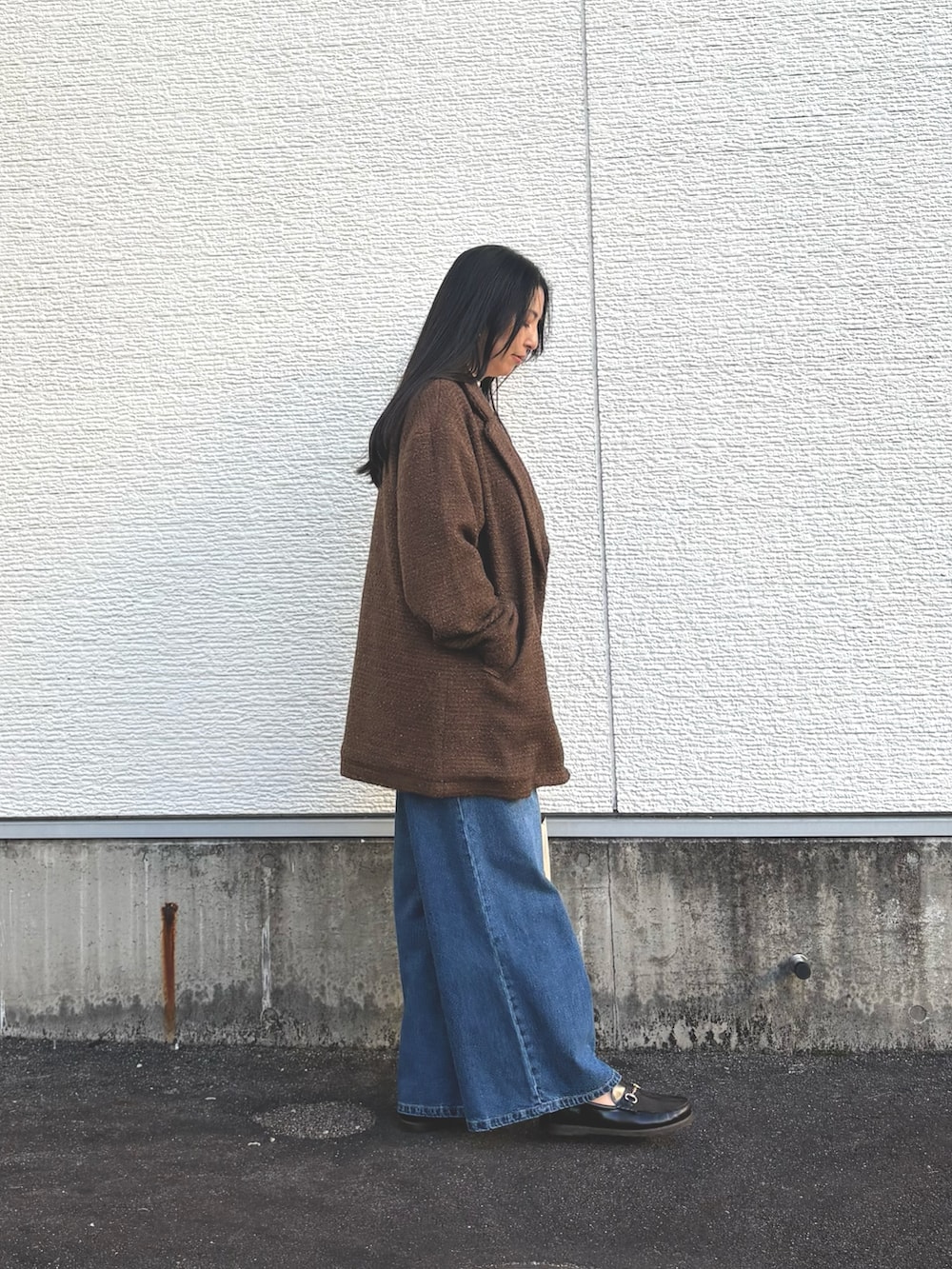 ホワイト系のニット/セーター、ブラウン系のその他アウター、ブルー系のデニムパンツを着用したレディースの冬コーディネートの2枚目の写真