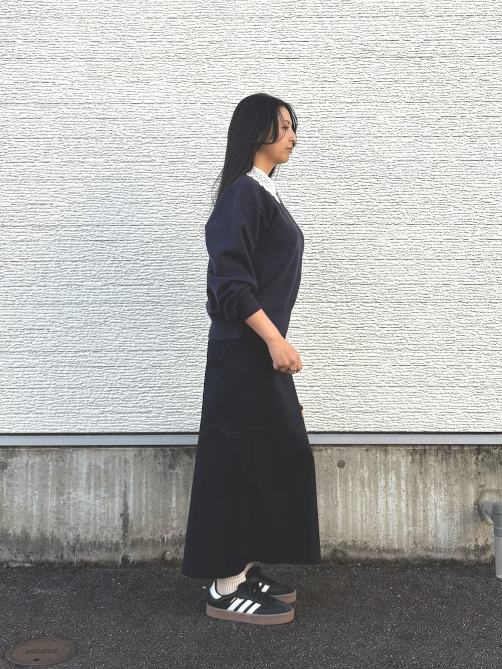 ブルー系のニット/セーター、ブルー系のスカート、ホワイト系のハンドバッグを着用したレディースの冬コーディネートの2枚目の写真