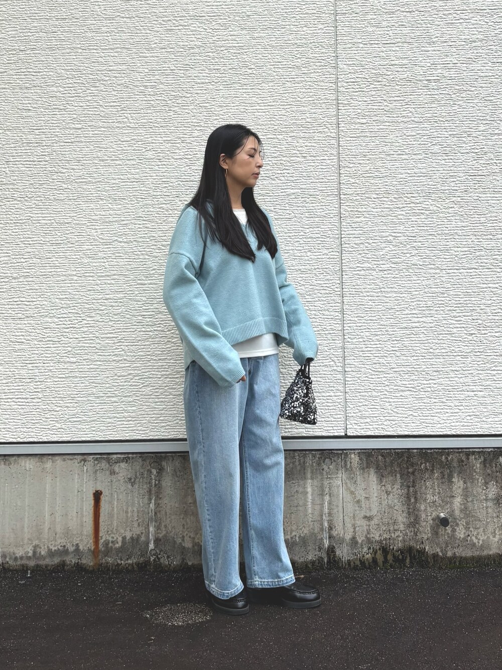 ブルー系のニット/セーター、ホワイト系のTシャツ/カットソー、ブルー系のデニムパンツを着用したレディースの秋コーディネートの3枚目の写真