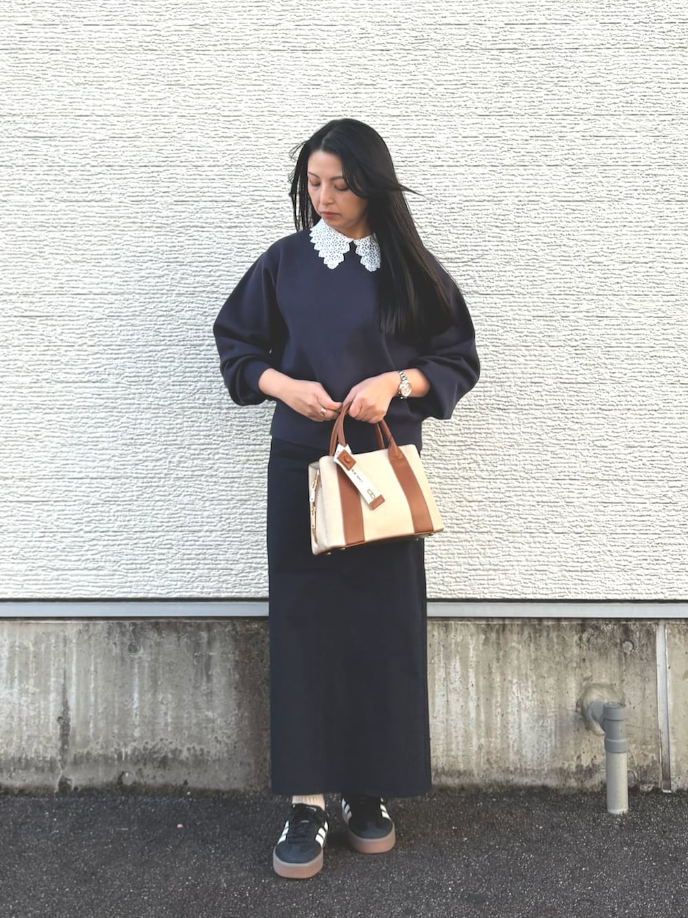 ブルー系のニット/セーター、ブルー系のスカート、ホワイト系のハンドバッグを着用したレディースの冬コーディネートの5枚目の写真