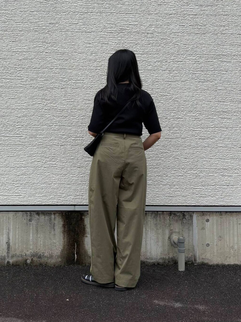 ブラック系のニット/セーター、グリーン系のその他パンツ、ブラック系のショルダーバッグを着用したレディースの春コーディネートの2枚目の写真