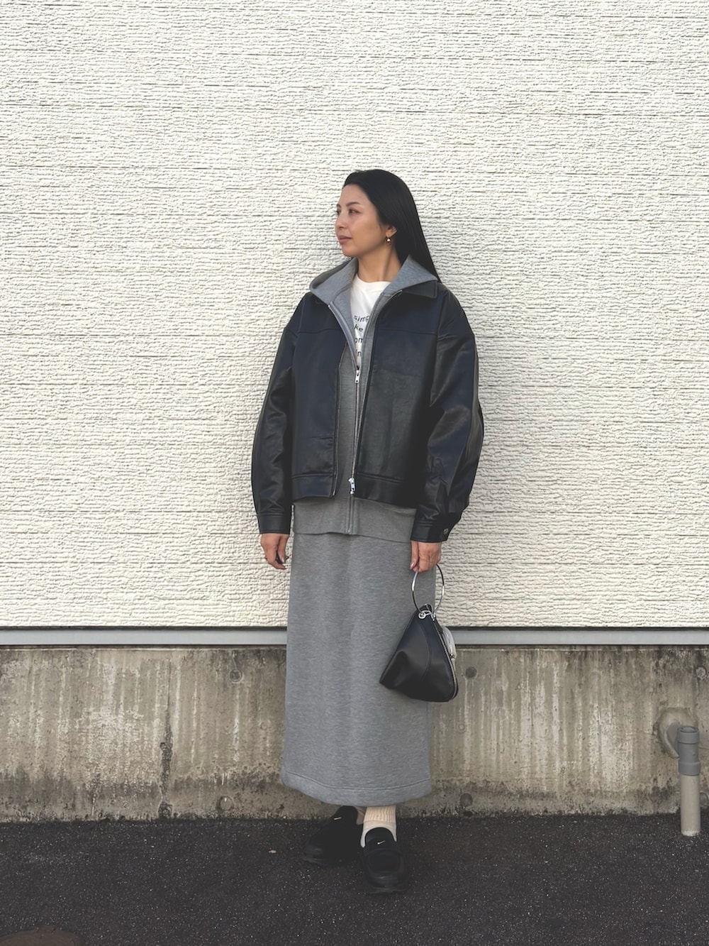 グレー系のスカート、ブラック系のスニーカー、グレー系のパーカーを着用したレディースの春コーディネートの4枚目の写真