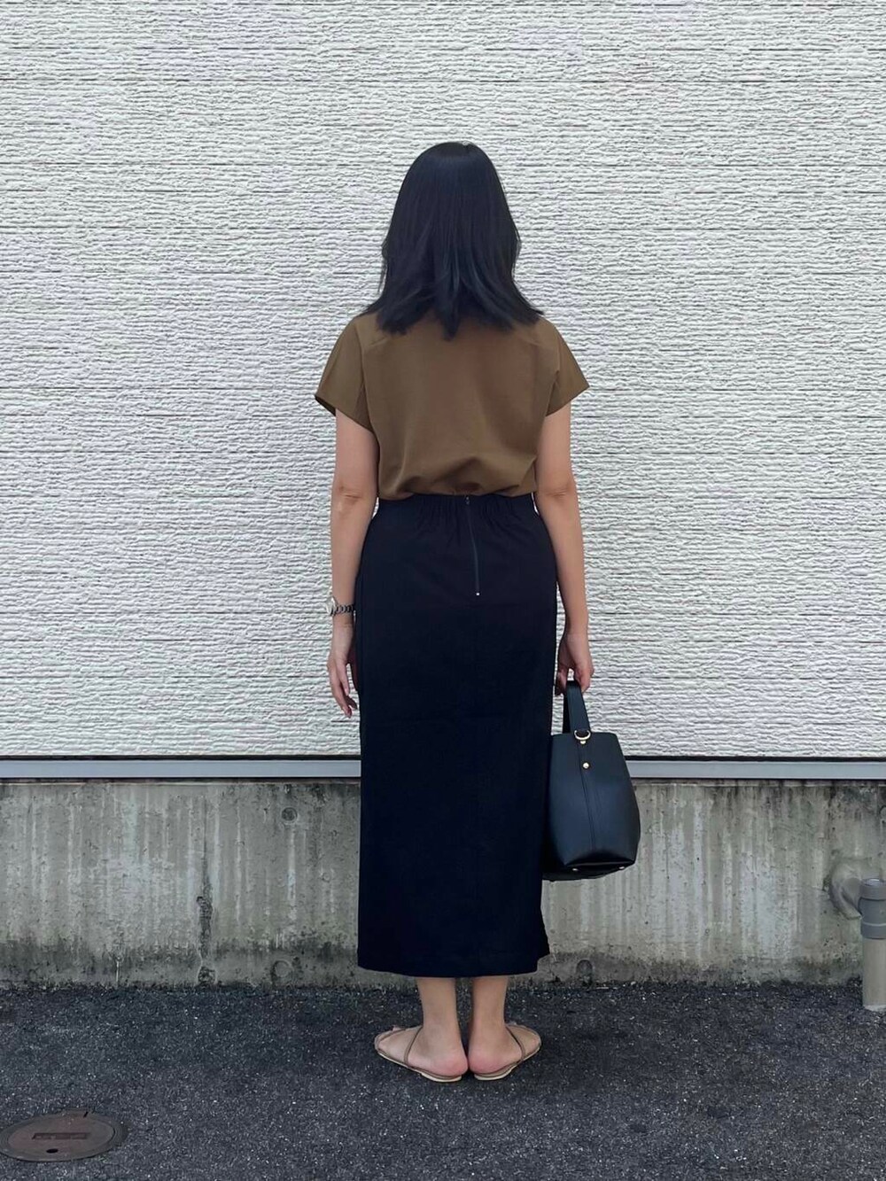 ブラウン系のTシャツ/カットソー、ブラック系のトートバッグ、ブラック系のスカートを着用したレディースの夏コーディネートの3枚目の写真