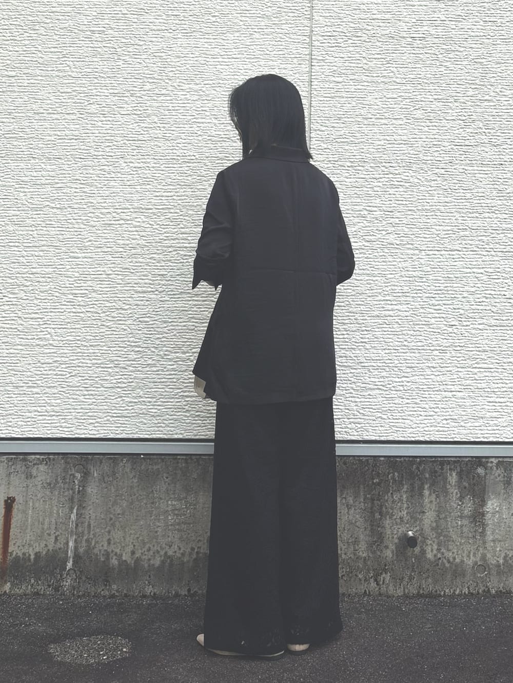ブラック系のその他アウター、ブラック系のその他パンツ、グレー系のハンドバッグを着用したレディースの秋コーディネートの3枚目の写真
