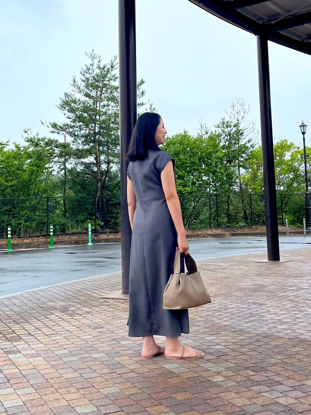 ベージュ系のハンドバッグ、グレー系のワンピースを着用したレディースの夏コーディネートの2枚目の写真