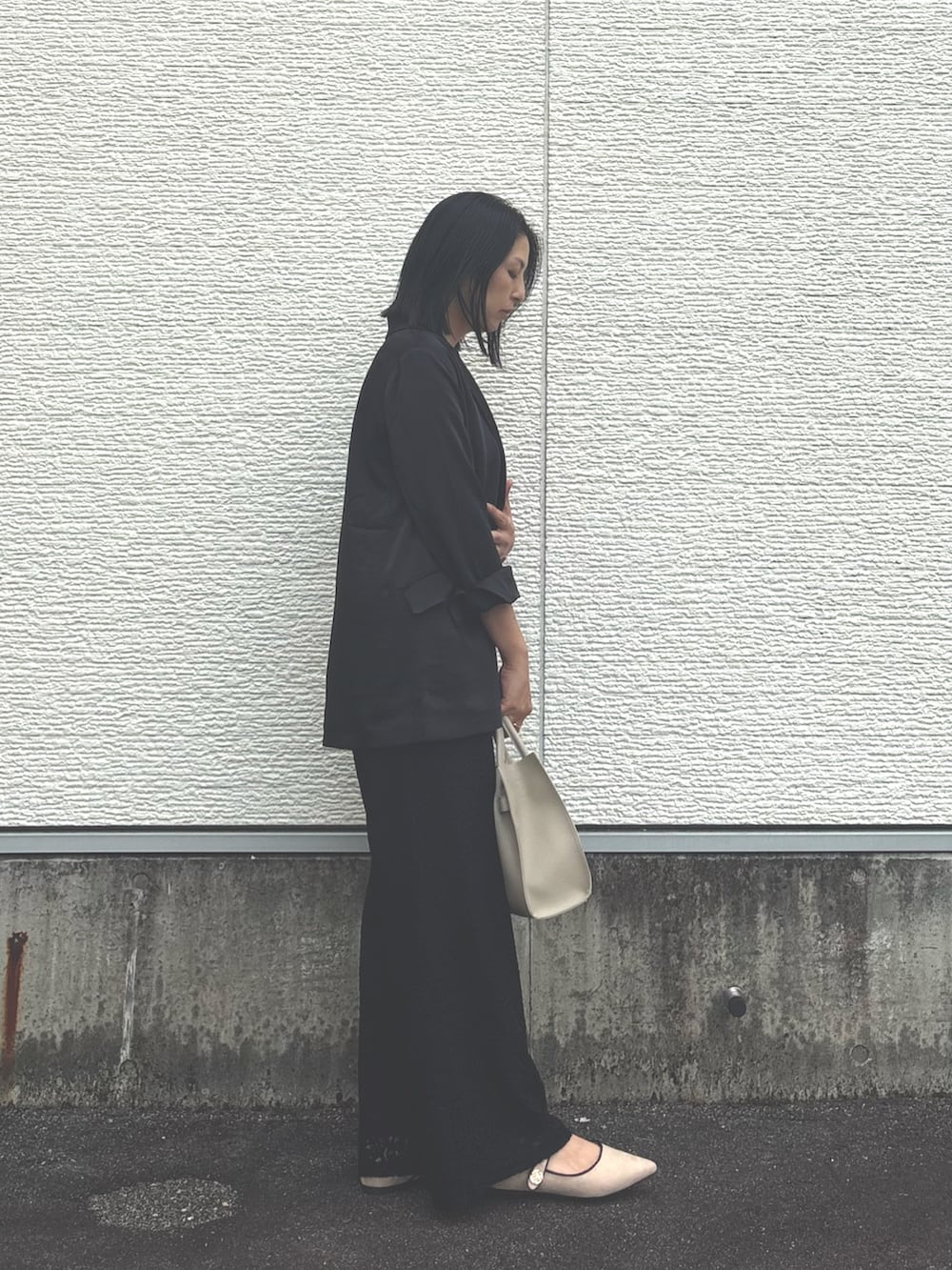 ブラック系のその他アウター、ブラック系のその他パンツ、グレー系のハンドバッグを着用したレディースの秋コーディネートの2枚目の写真