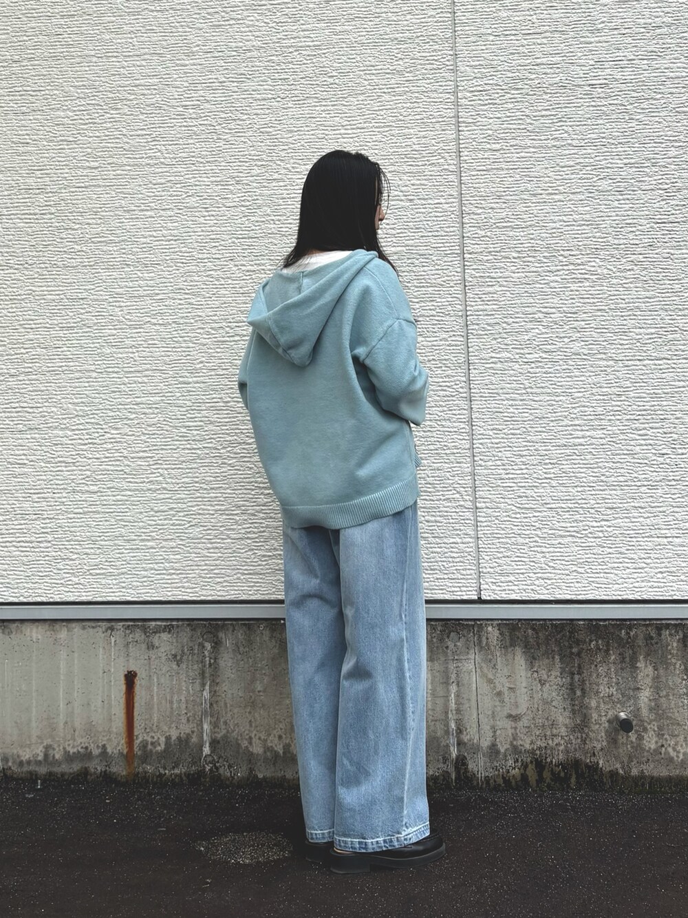 ブルー系のニット/セーター、ホワイト系のTシャツ/カットソー、ブルー系のデニムパンツを着用したレディースの秋コーディネートの2枚目の写真